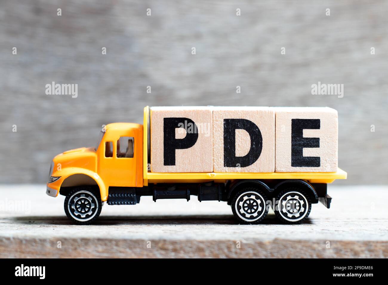 Truck hold letter block in word PDE (abbreviation of permitted daily  exposure, partial differential equation or personal development education)  on woo Stock Photo - Alamy