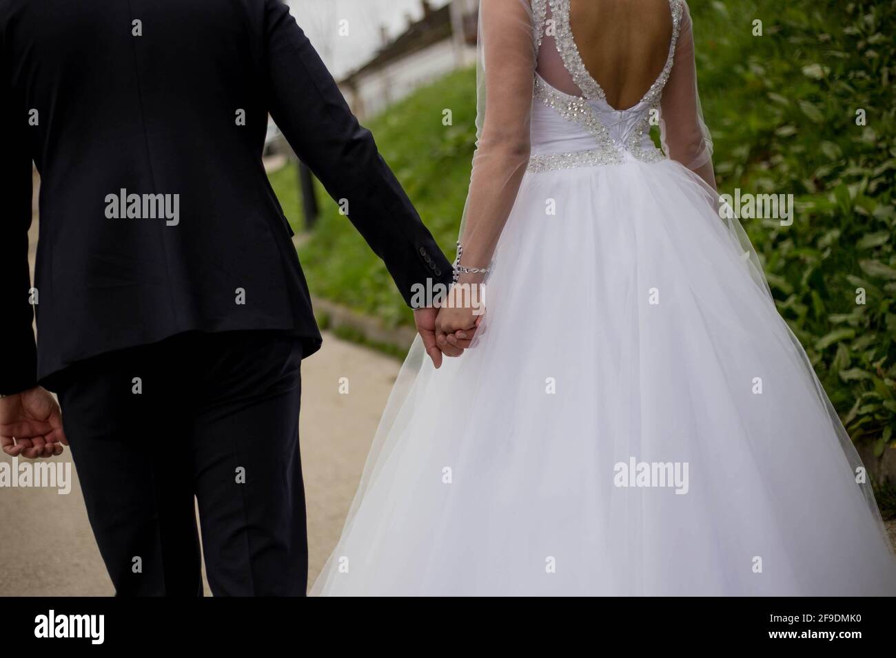 A back view of a bride and groom holding hands at their wedding Stock ...