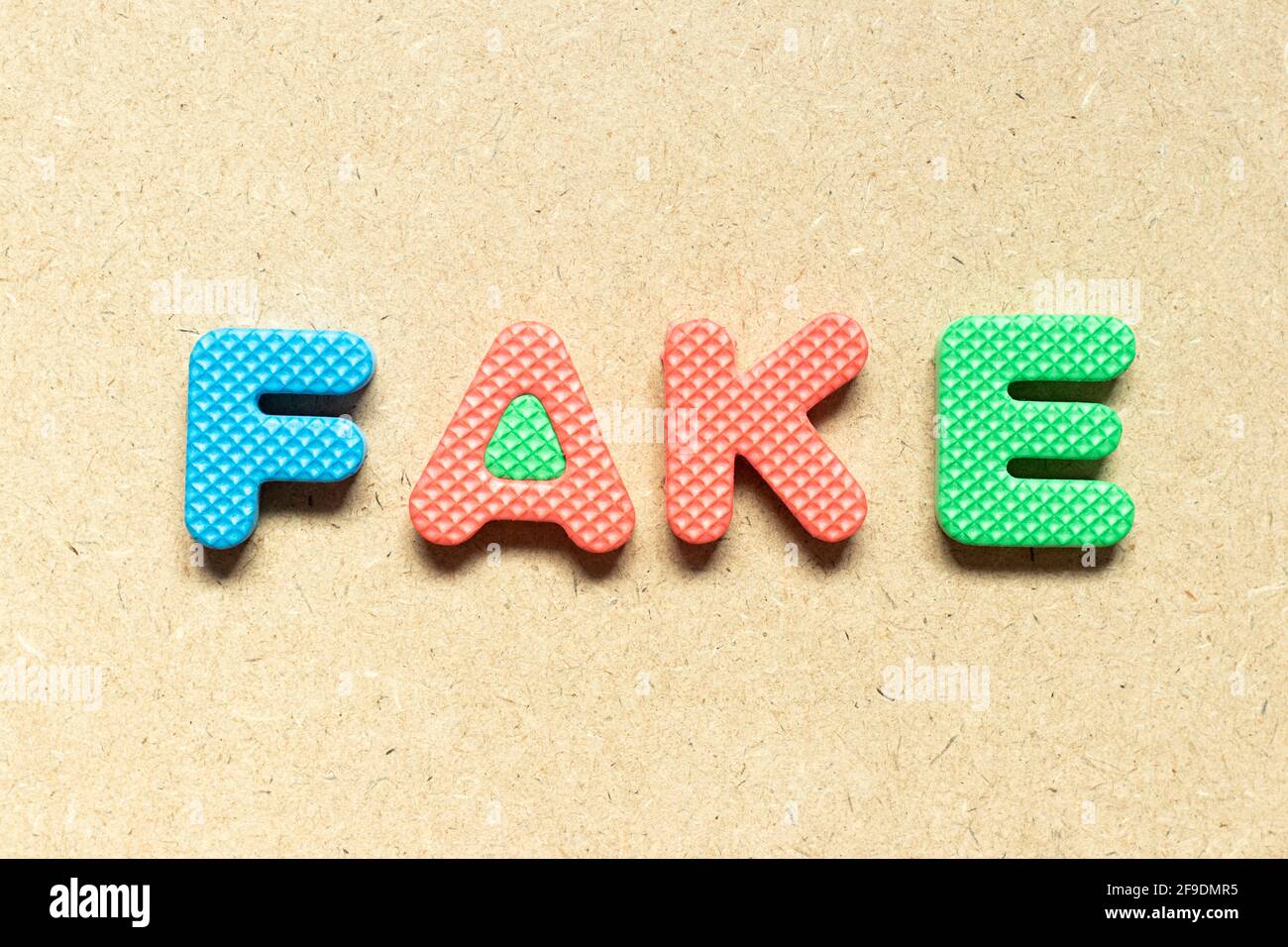 Foam alphabet letter in word fake on wood background Stock Photo Alamy