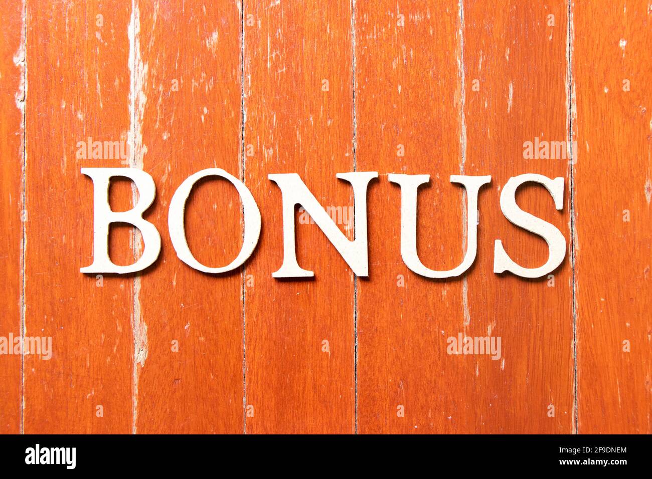 Alphabet letter in word bonus on old red color wood plate background