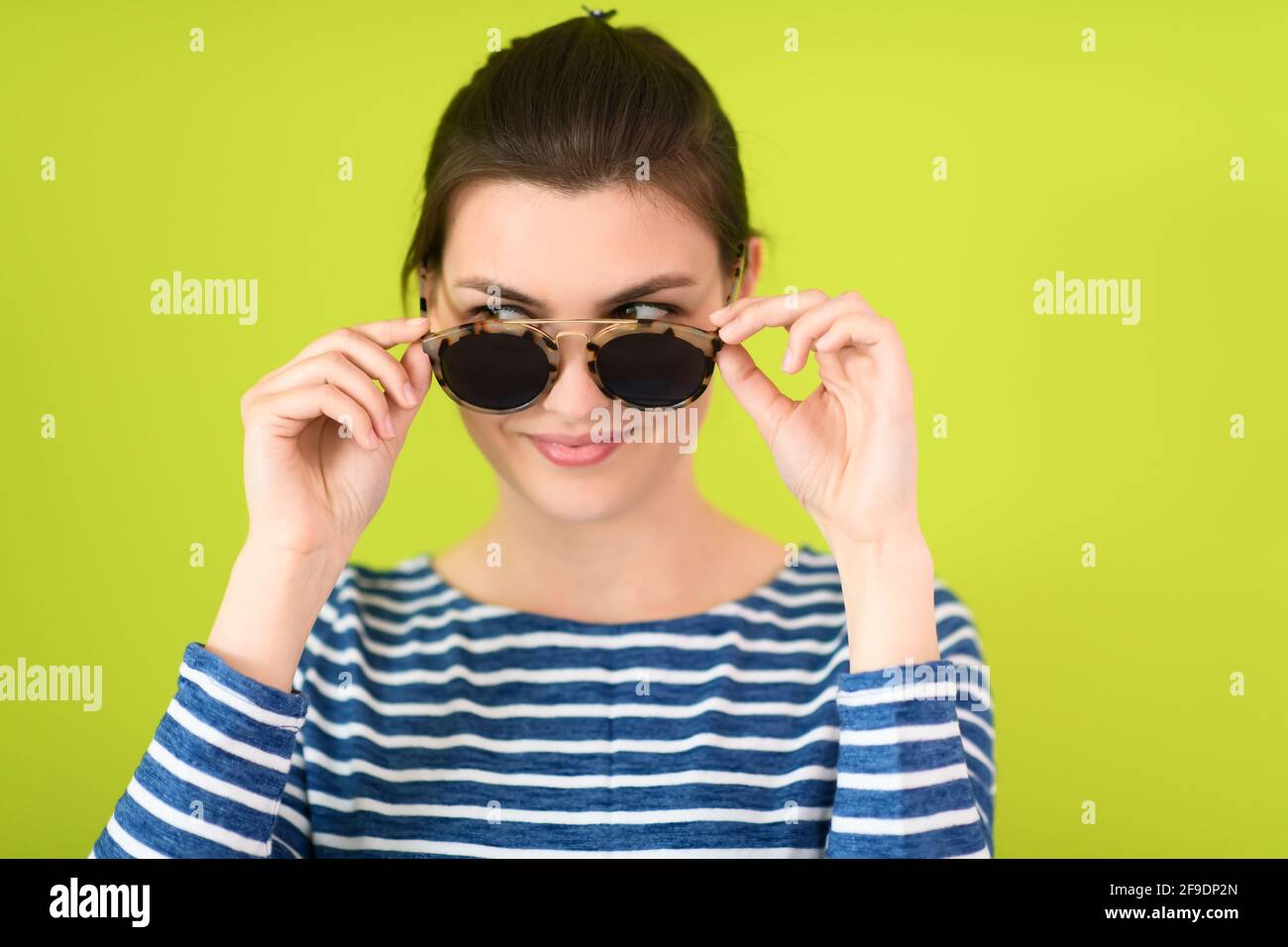 woman in sunglasses posing in front of a green background Stock Photo ...