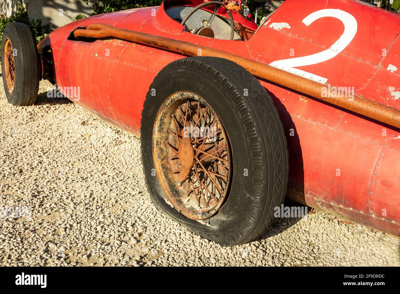 Red racing car with the number 2 on it, and it has a flat tyre Stock