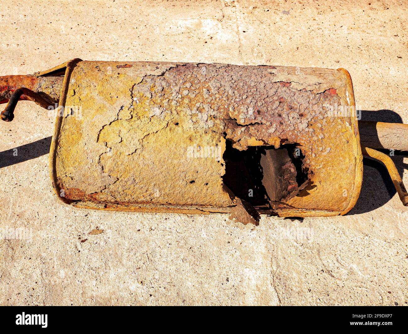 Old rusty car muffler with a burnt hole Stock Photo Alamy