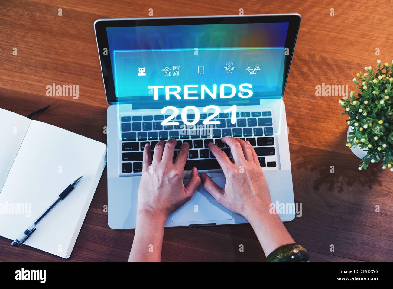 Trends for 2021 augmented reality (AR) floating screen with hand typing keyboard on laptop and notebook on wood table,Digital Business disruption or m Stock Photo