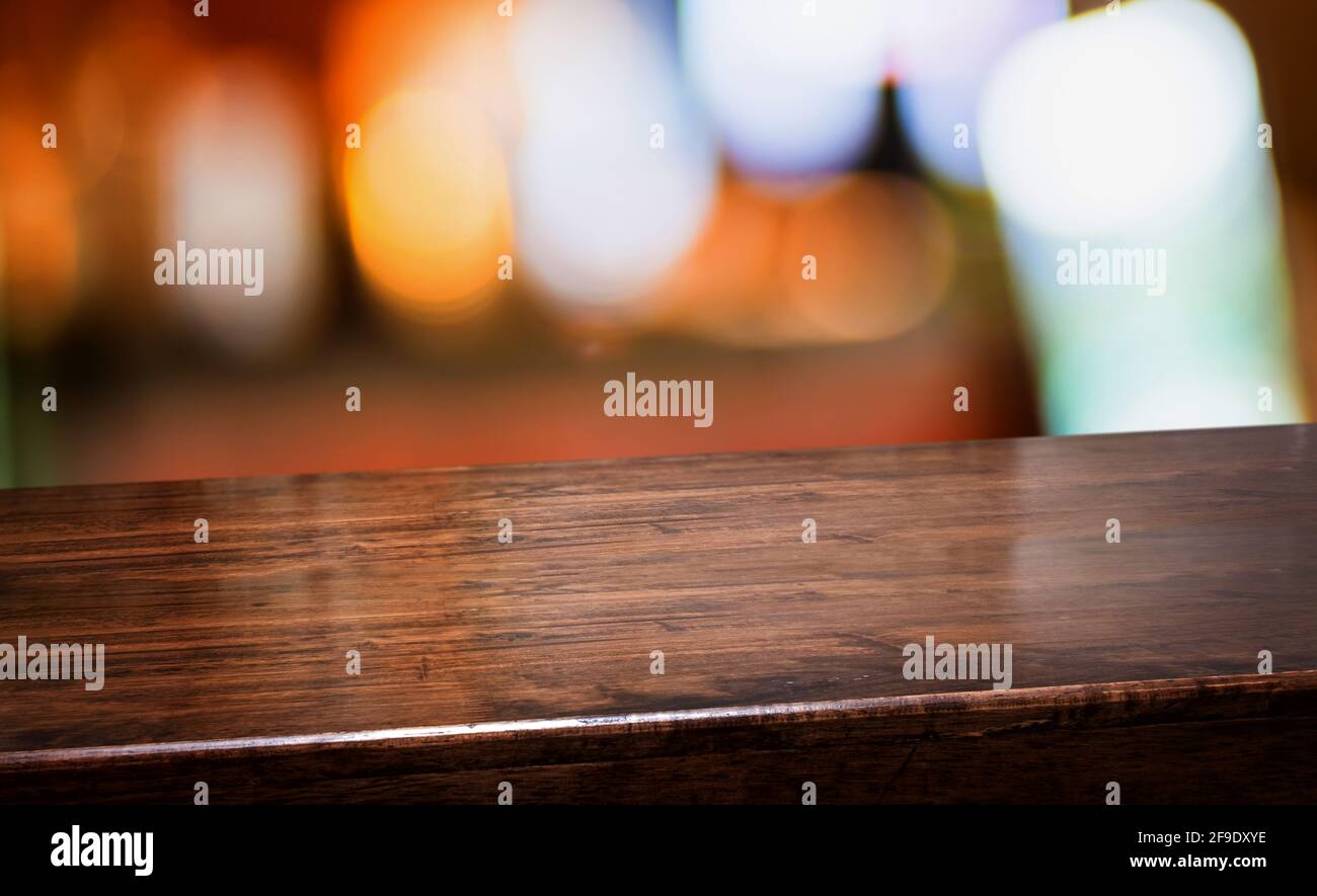 bar nightclub background.Empty diagonal brown wooden table with blur bar restaurant bokeh lights,banner mockup template for display of product Stock Photo