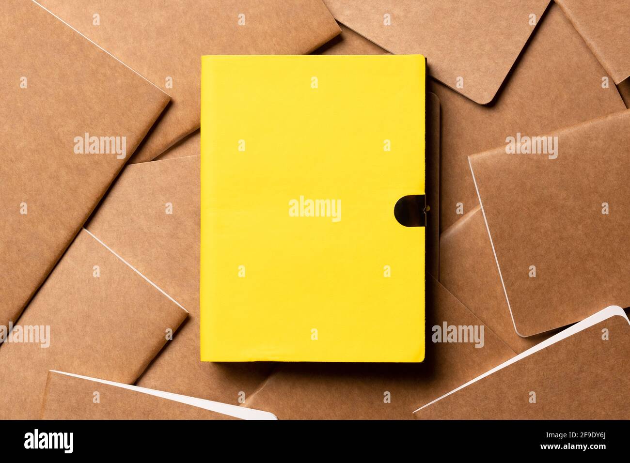 yellow notebook on brown kraft notebook disorder alignment on table background.mockup template for display content or design.content marketing concept Stock Photo