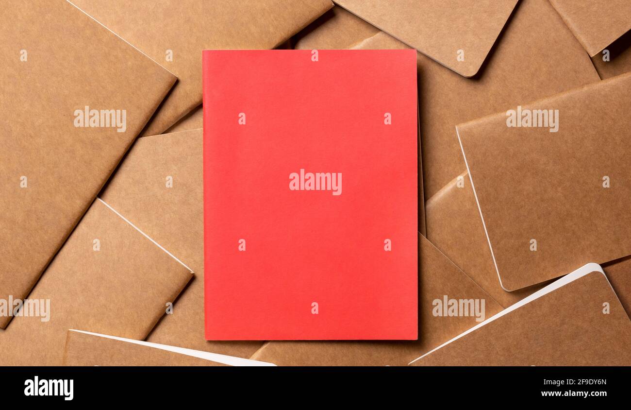 red notebook on brown kraft notebook disorder alignment on table background.mockup template for display content or design.content marketing concept Stock Photo