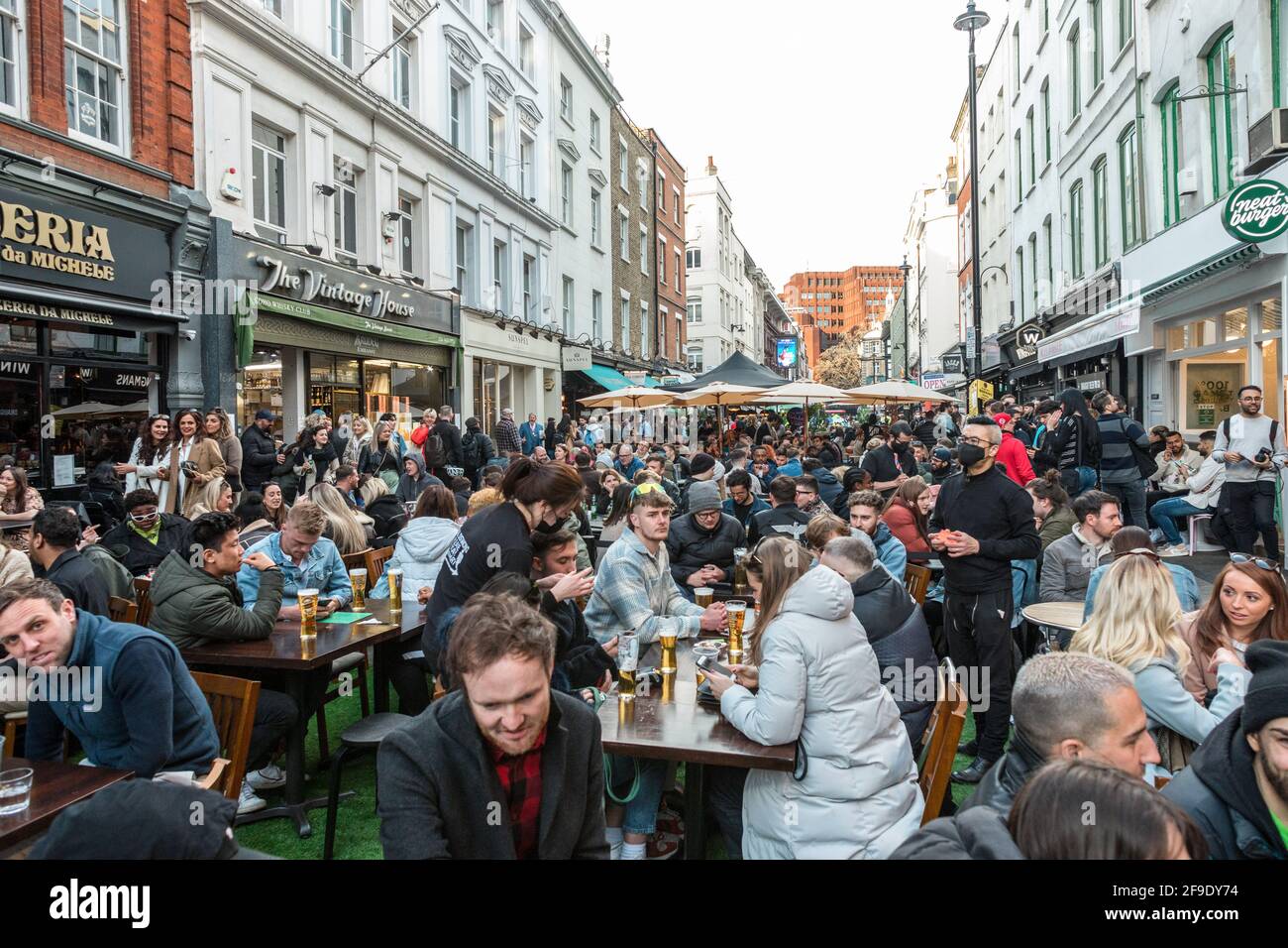 Crowds of people in restaurants and bars in Soho, London, where outdoor