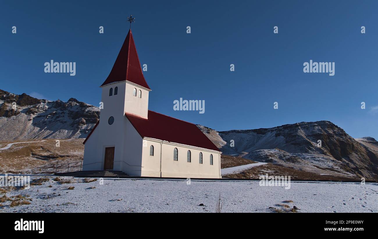 Beautiful view of the small church of village Vík í Mýrdal located on the southern coast of Iceland with white wall and red colored roof. Stock Photo