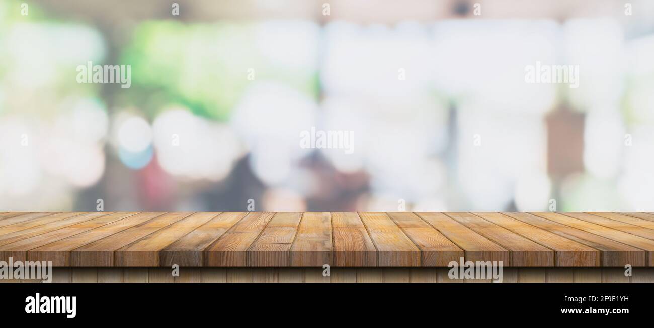 Empty wood table and blurred light table in coffee shop and cafe with ...