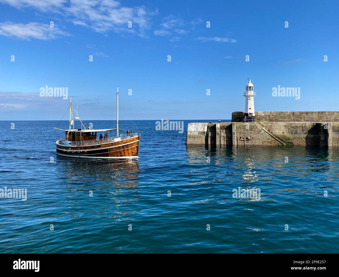 A tour guide boat returns to Mevagissey harbour in Cornwall. Stock Photo