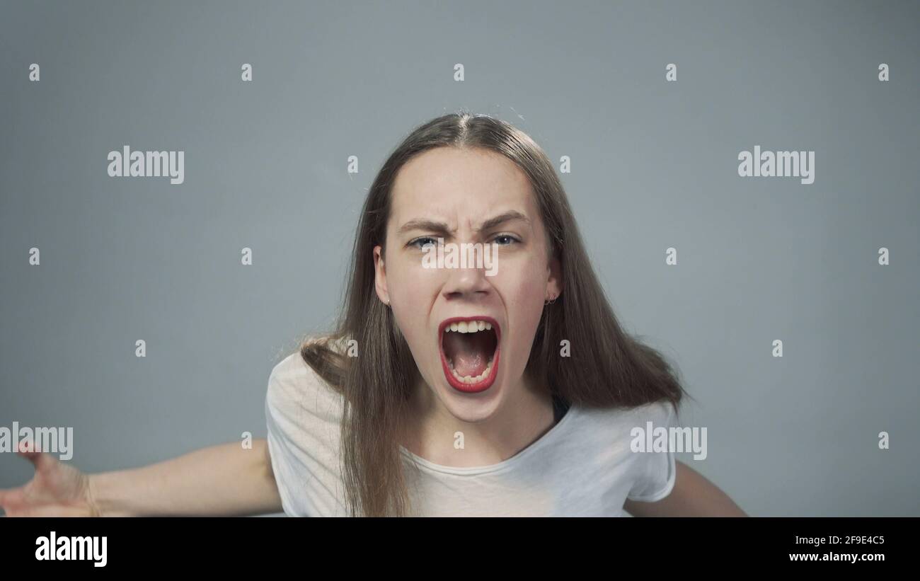 Photo of young yelling girl on grey Stock Photo