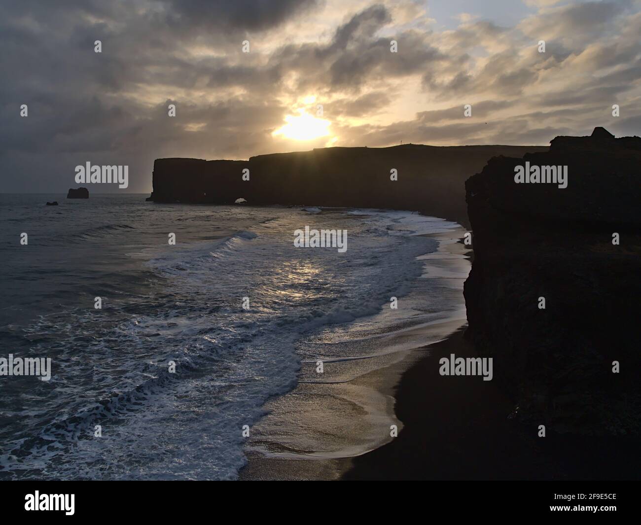 Stunning view of the silhouettes of the rugged cliffs of Dyrhólaey peninsula on the southern coast of Iceland near ring road with Kirkjufjara beach. Stock Photo