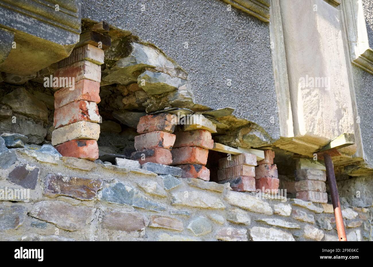 Brick brace support holding up fragile building wall Stock Photo