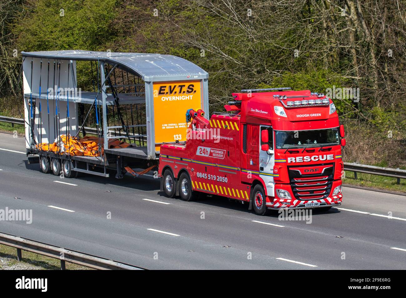 Damaged curtain sided lorry, curtainsider, tautliner, curtainsided, curtainside trailers being towed by Hough green 24 roadside assistance truck, on the M61 Motorway. Stock Photo