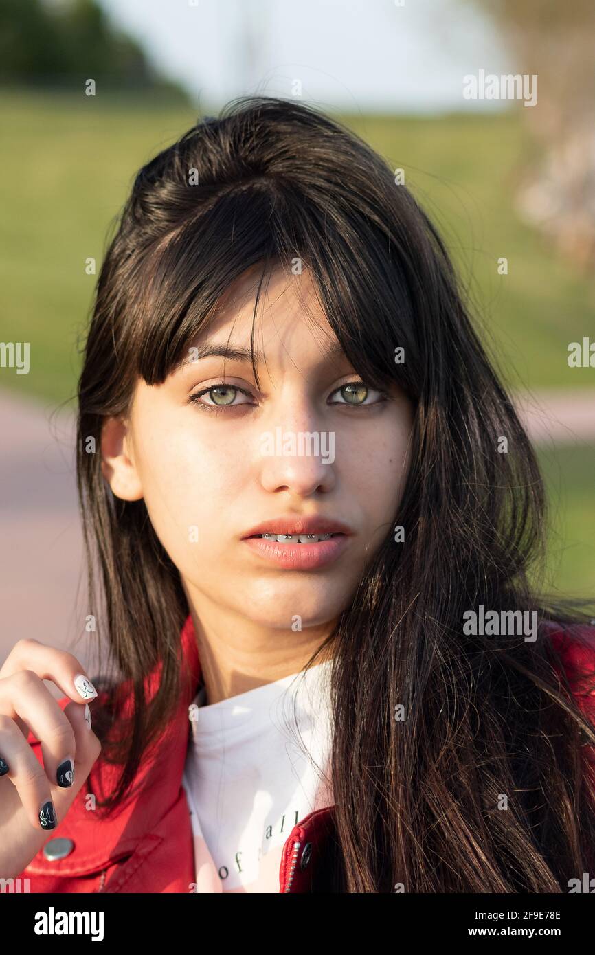 portrait of green eyed latina teenager in the park with red leather jacket  Stock Photo - Alamy