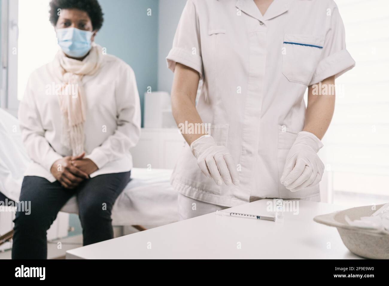 Cropped unrecognizable female doctor in latex gloves and face shield ...