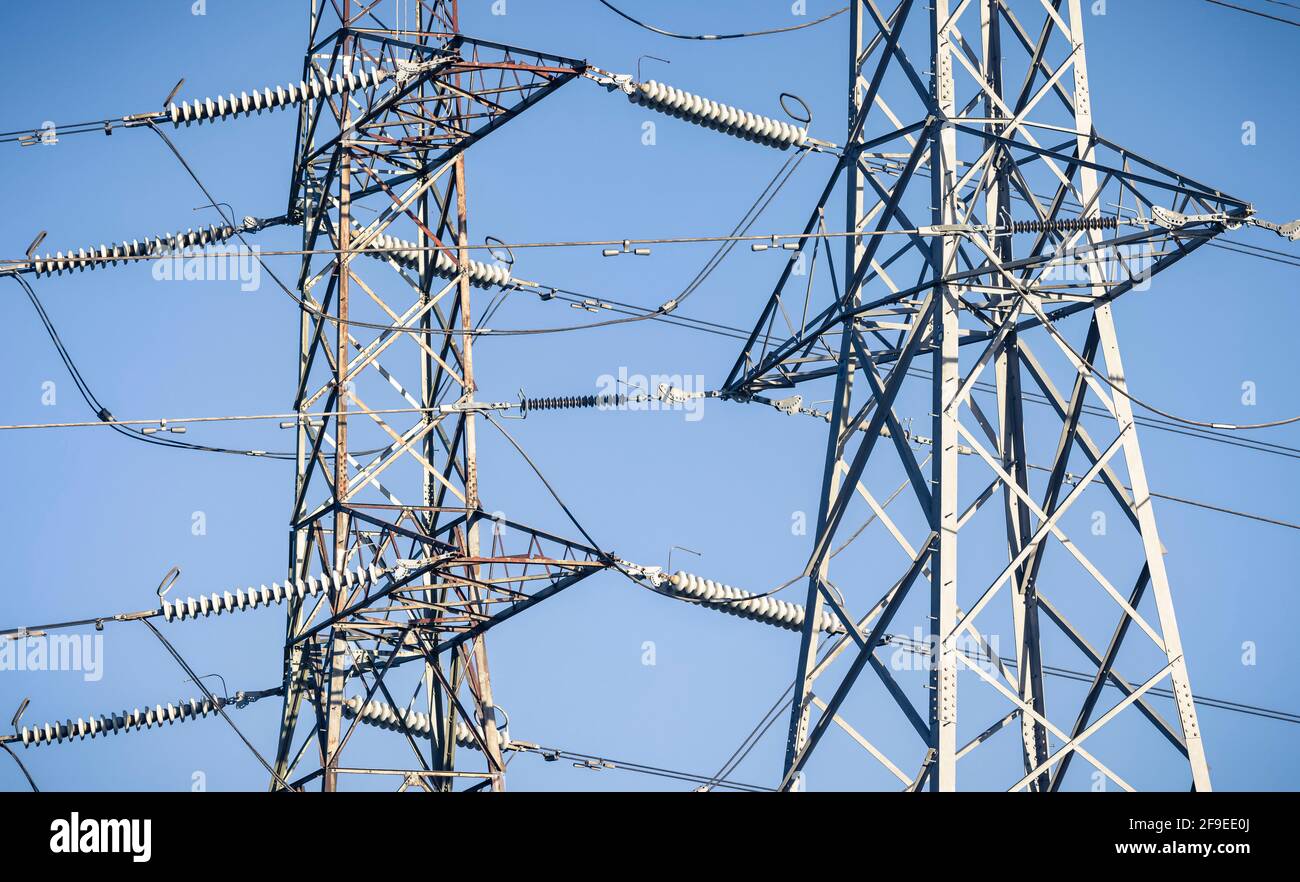 Detail of electricity pylons against a blue sky, depicting UK National Grid and electricity power supply Stock Photo