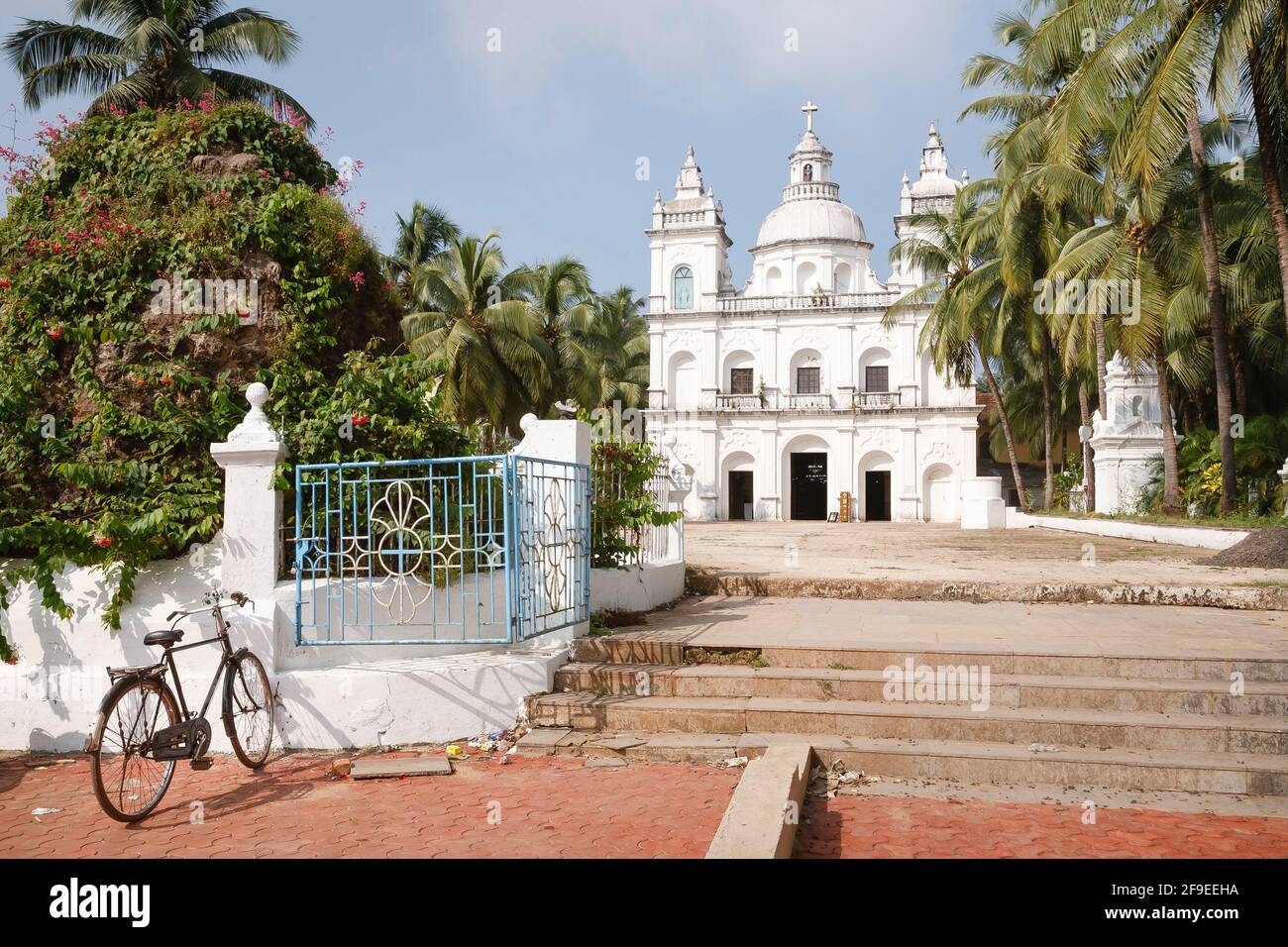 Bicycle outside the Church of St Alex, a large Catholic Christian church in Calangute, North Goa, India Stock Photo