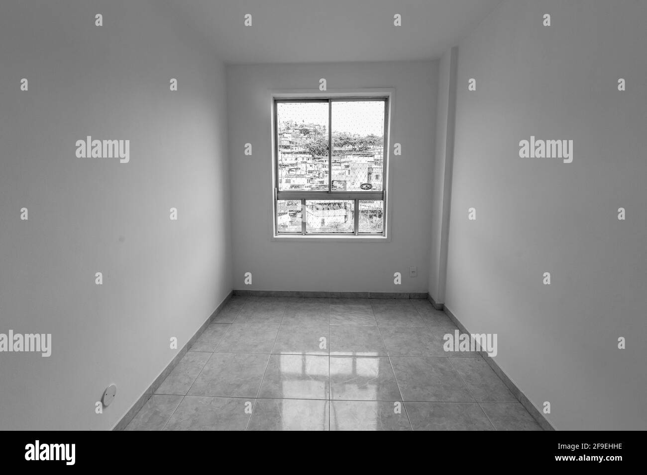 An empty room of a new apartment with white walls and a light from a window on the floor Stock Photo