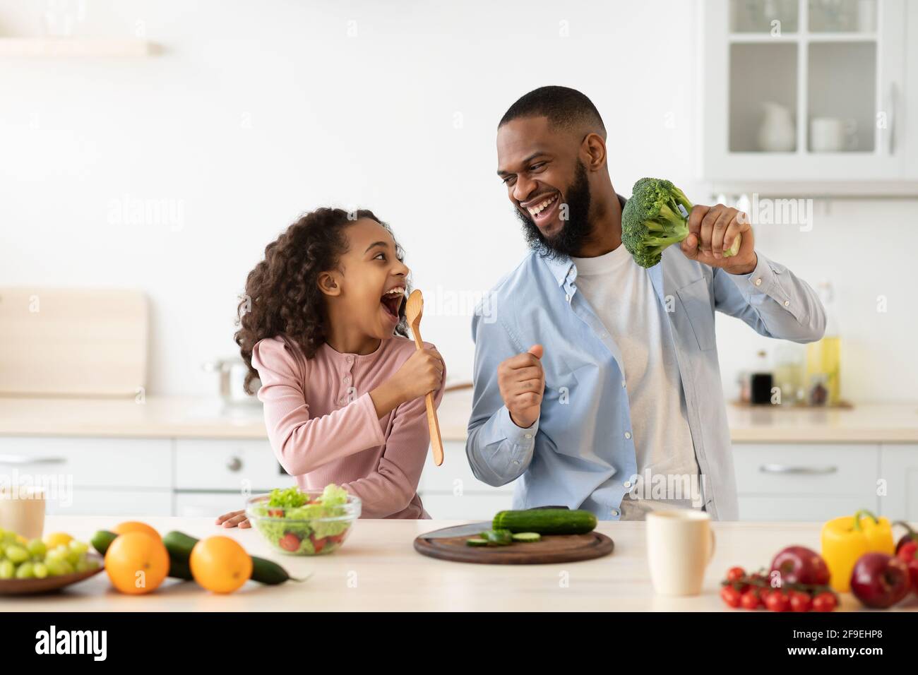 Black father and daughter singing in the kitchen together Stock Photo ...