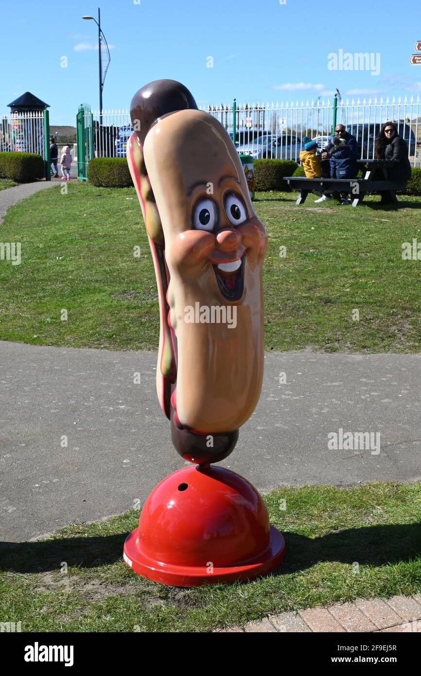 Extra large plastic hotdog with face, on a red plastic stand Stock Photo