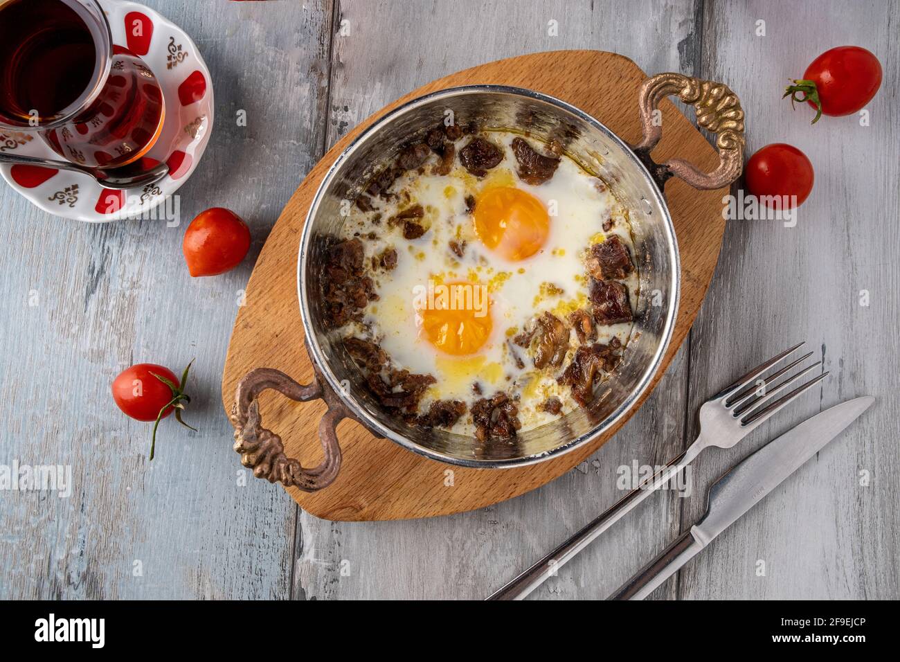 Turkish scrambled eggs with roasted meat in copper pan Stock Photo