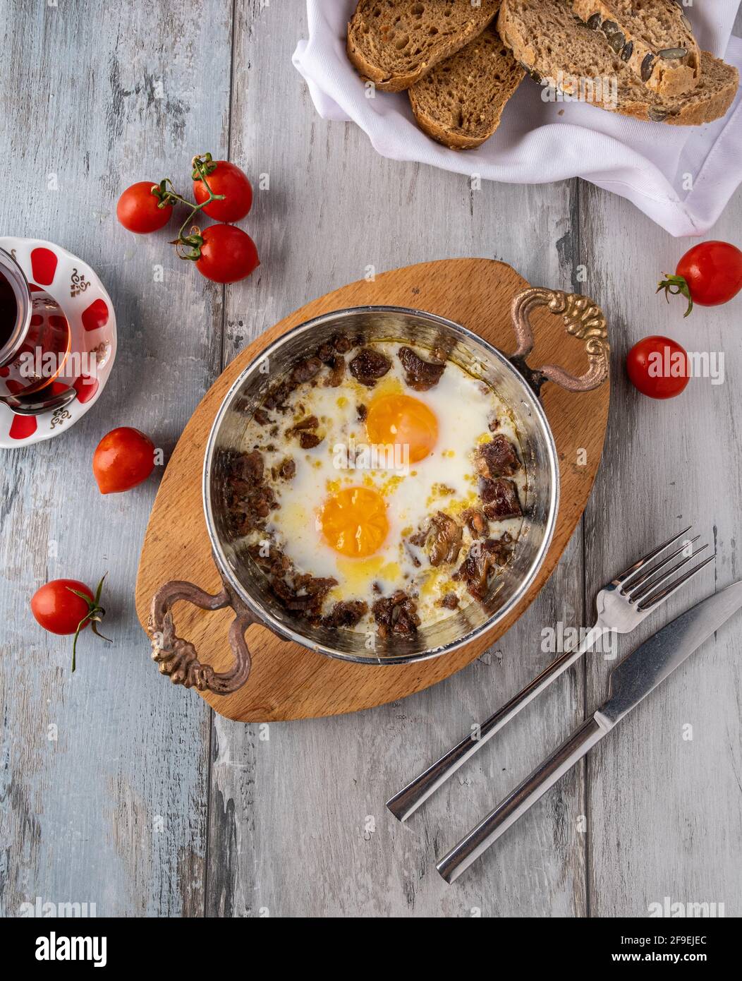 Turkish scrambled eggs with roasted meat in copper pan Stock Photo