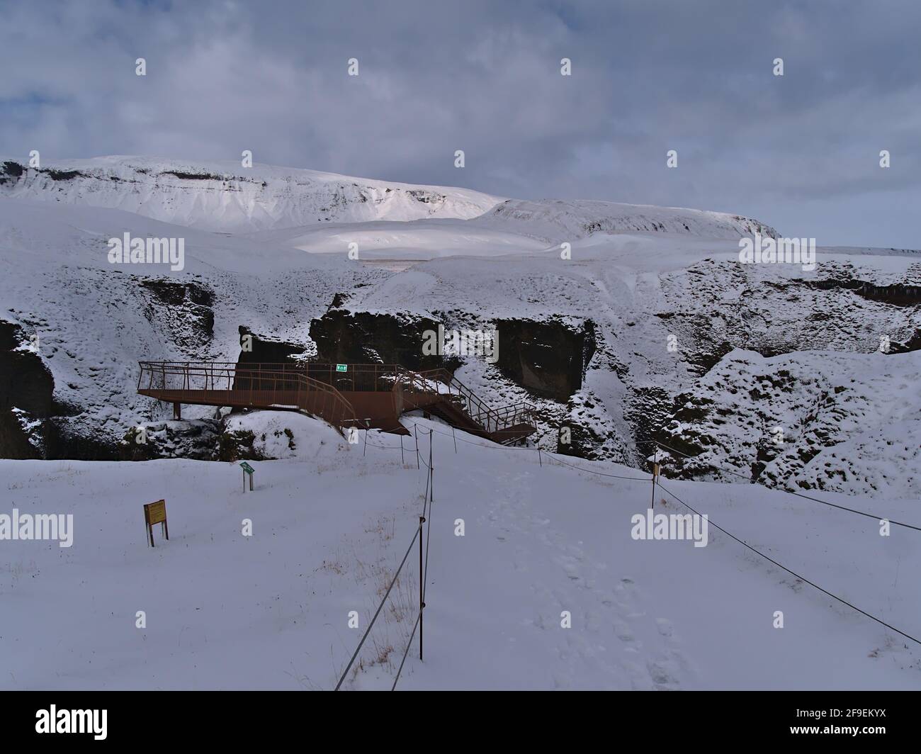 Snow-covered footpath and observation platform above famous canyon Fjaðrárgljúfur in southern Iceland near route 1 and Kirkjubæjarklaustur. Stock Photo