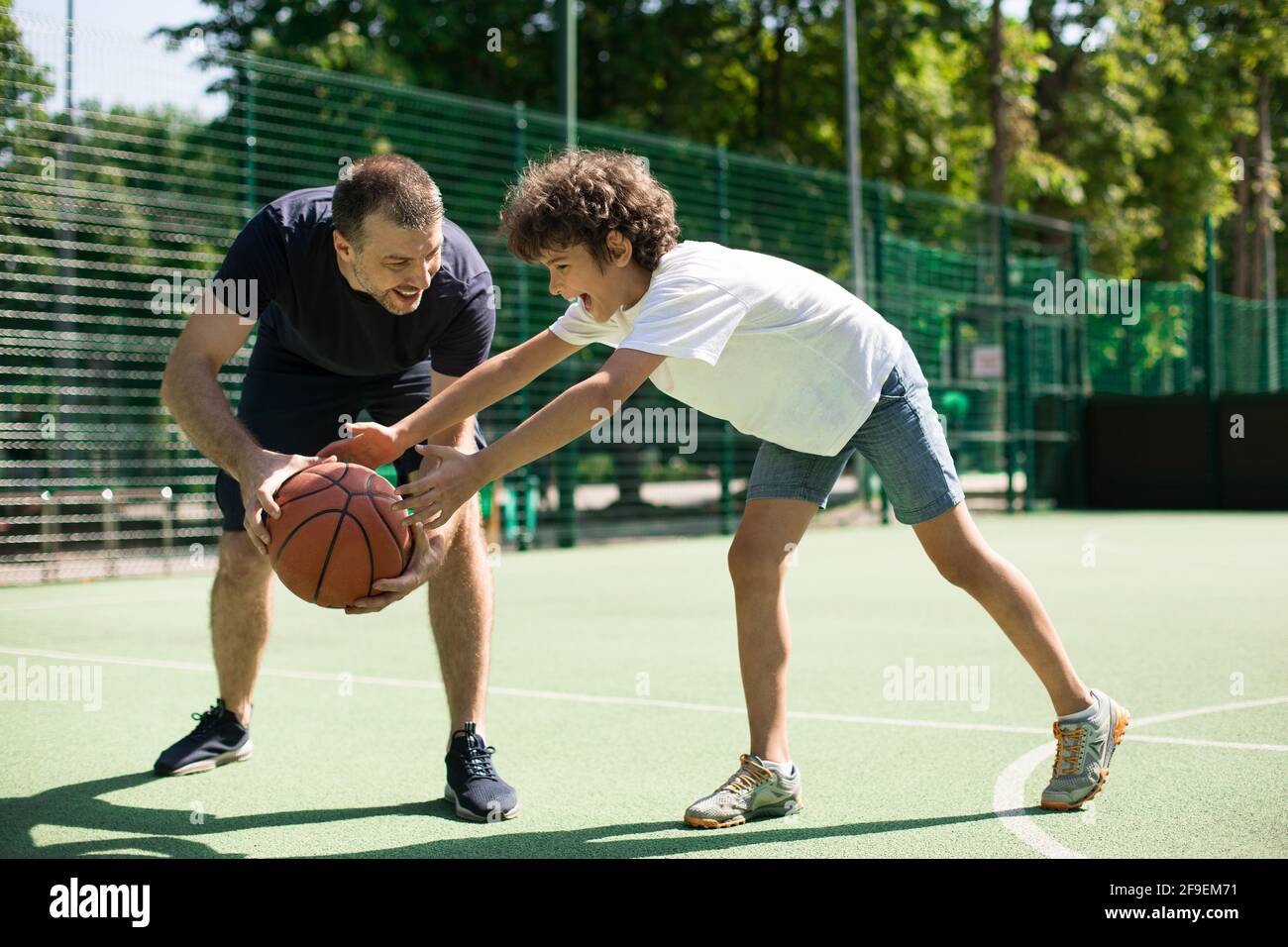Kid dribbling ball playing basketball hires stock photography and