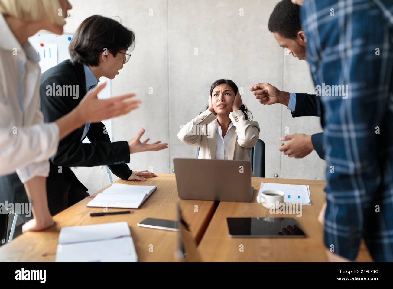 Aggressive Coworkers Shouting Criticizing Unhappy Victimized Female Worker In Office Stock Photo