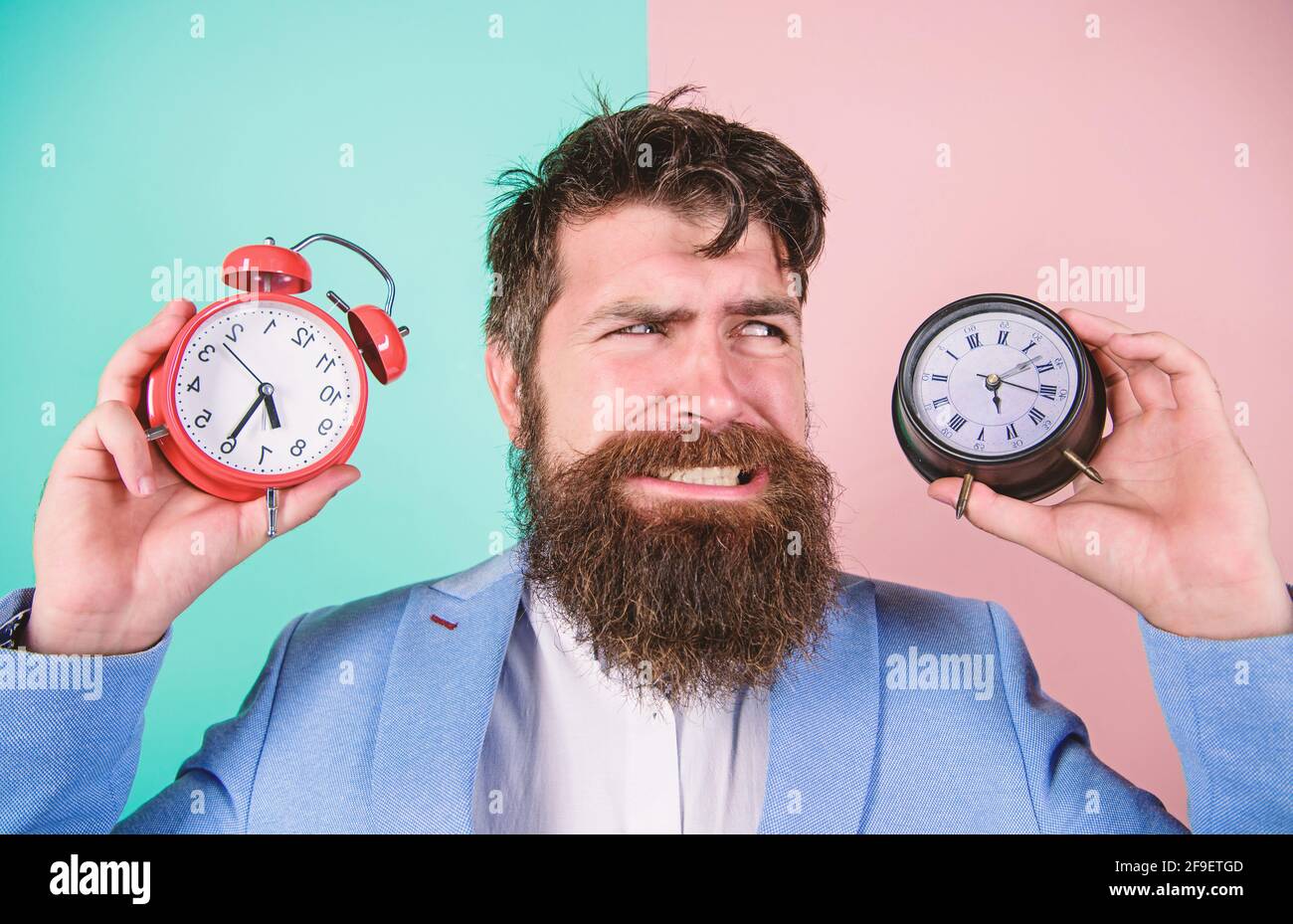 Does changing clock mess with your health. Man bearded hipster hold two