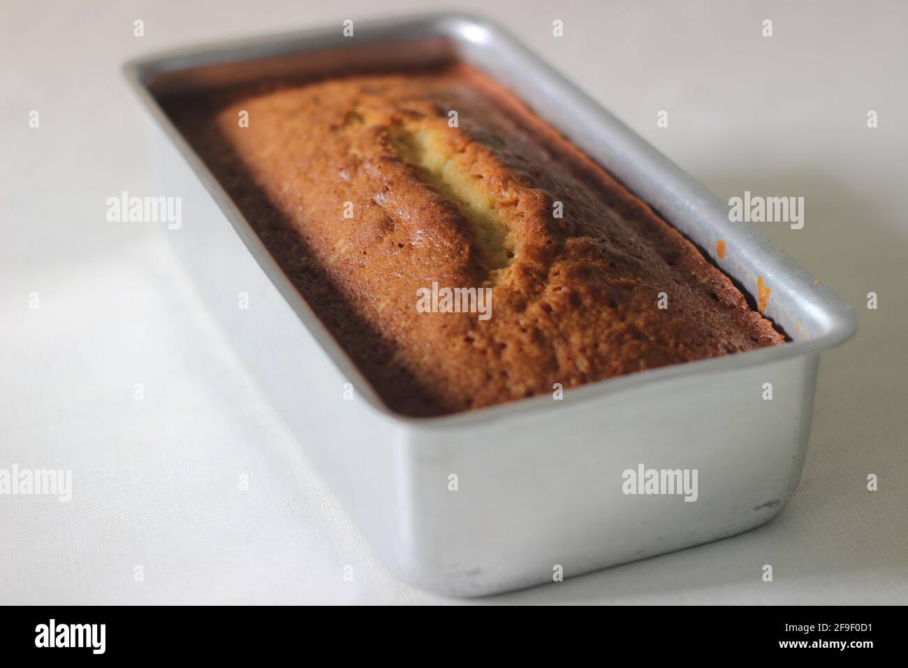 Home baked vanilla cake inside the loaf tin tray. Shot on white background Stock Photo Alamy
