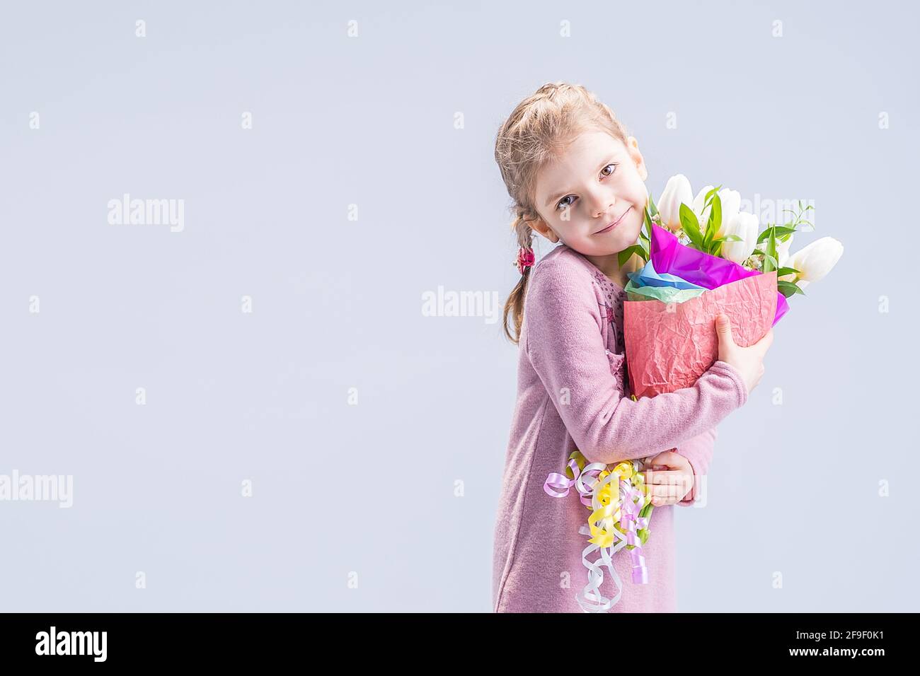 beautiful little girl with a bouquet of white tulips Stock Photo - Alamy