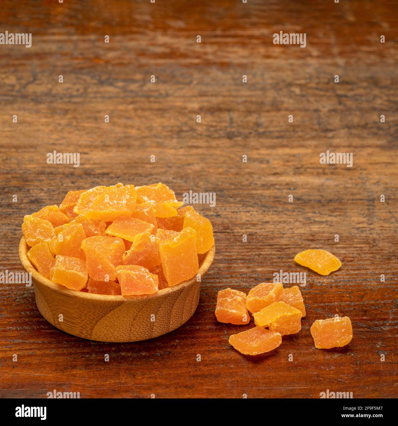 dried mango fruit diced small wooden bowl on a weathered wood