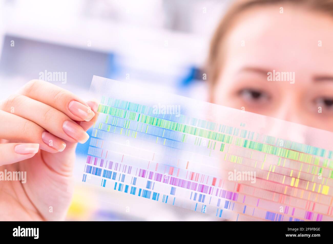 Young woman examines a spectroscopy picture in a quantum physics laboratory Stock Photo