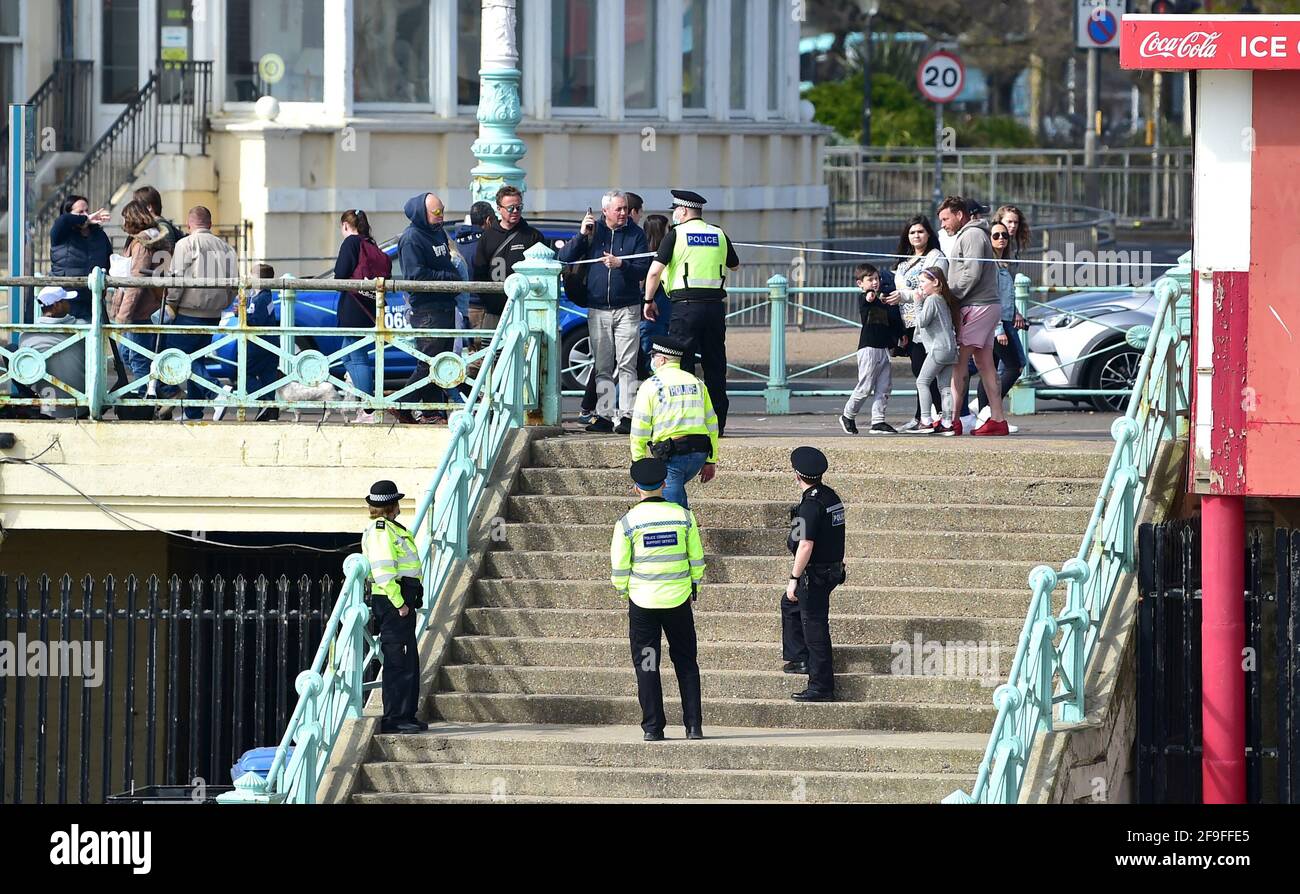Brighton UK 18th April 2021 - Police and PCSO's clear a section of Brighton beach today after it is believed a metal detectorist found a suspect item on the shingle, possibly a WW2 mortar shell near the pier : Credit Simon Dack / Alamy Live News Stock Photo