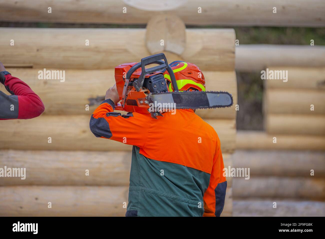 A worker holding a chainsaw in construction area Stock Photo