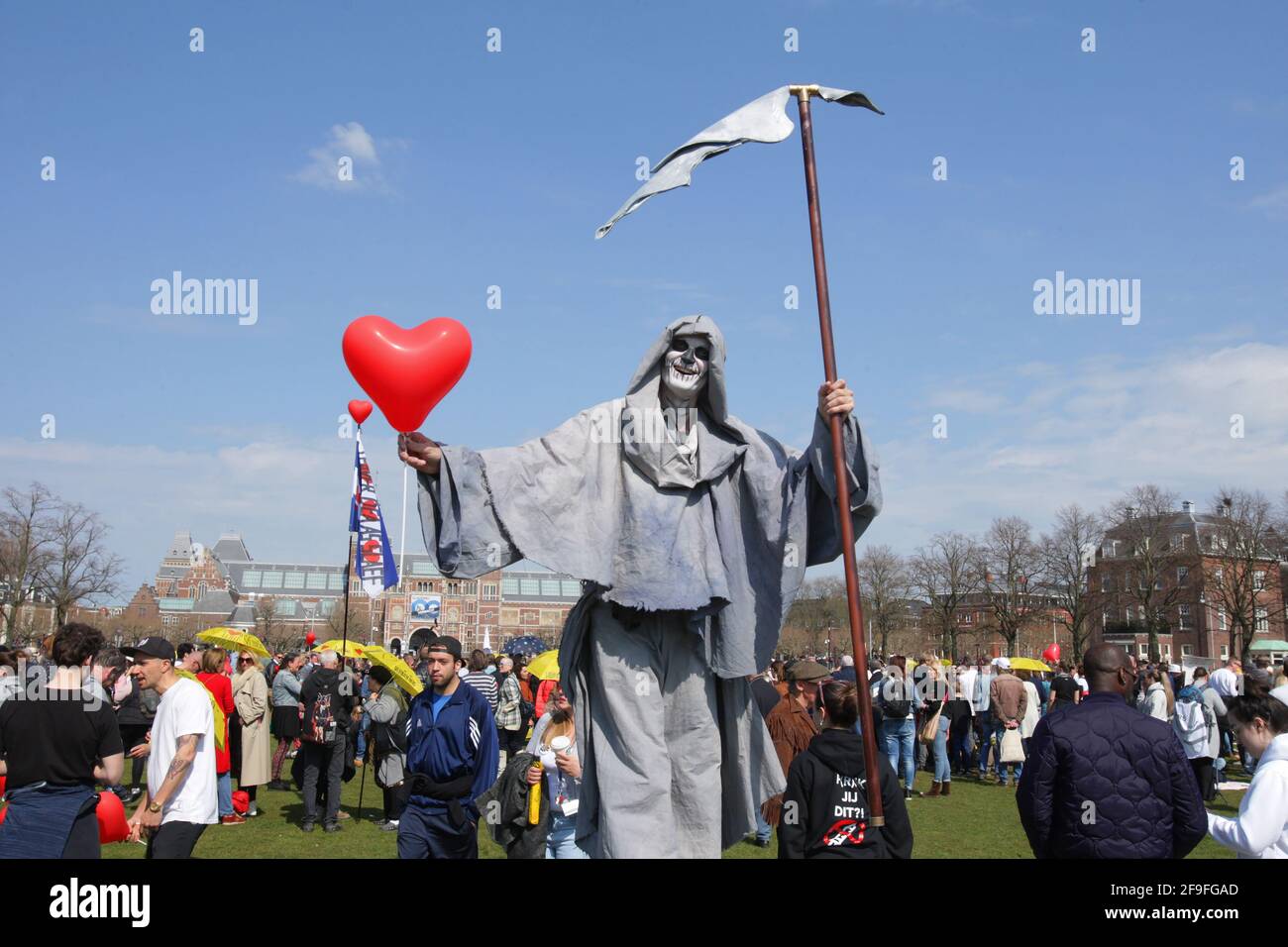 Anti-lockdown protester dressed as the grim reaper hold a ballon hart  during an illegal demonstration anti-vaccination and coronavirus measures at the Muaeumplein on April 18, 2021 in Amsterdam,Netherlands. (Photo by Paulo Amorim/Sipa USA) Stock Photo