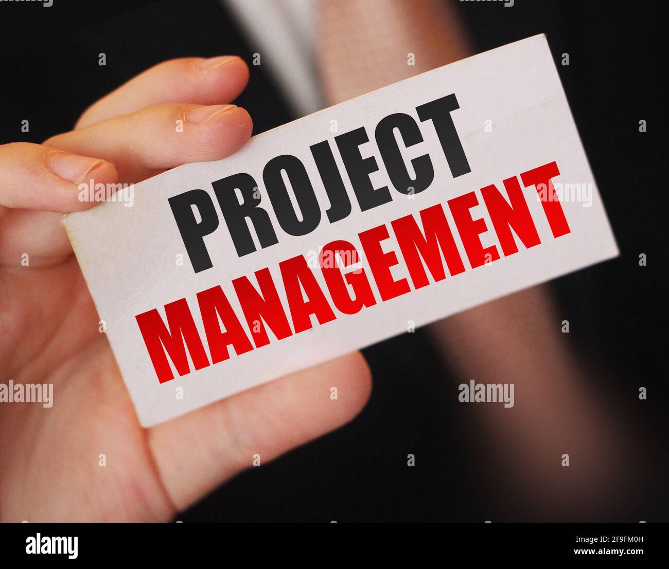 PROJECT MANAGEMENT words on card businessman holds. Bbusiness concept