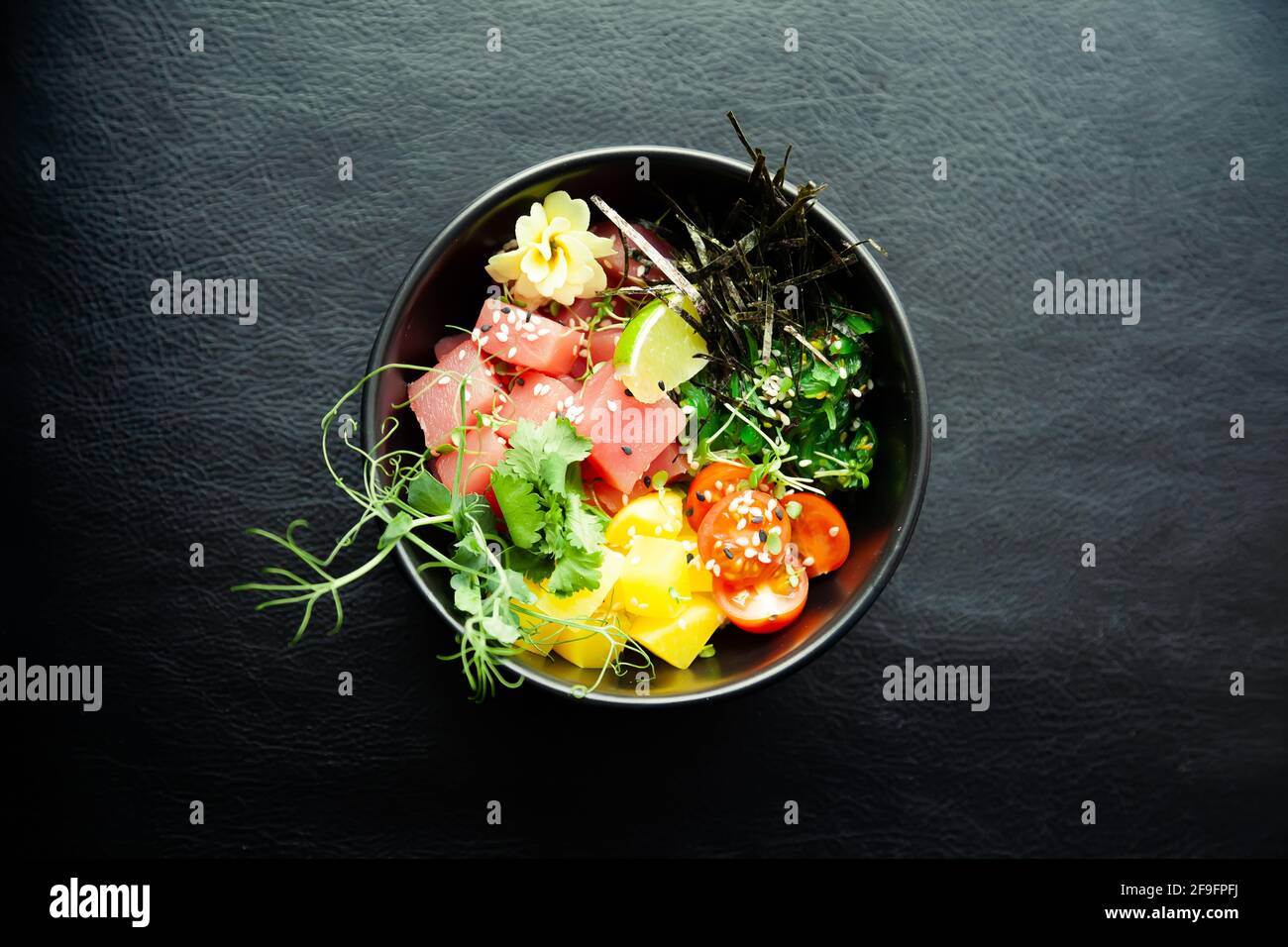 Poke salad with tuna in a bowl. Ingredients fresh tuna, cherry tomatoes