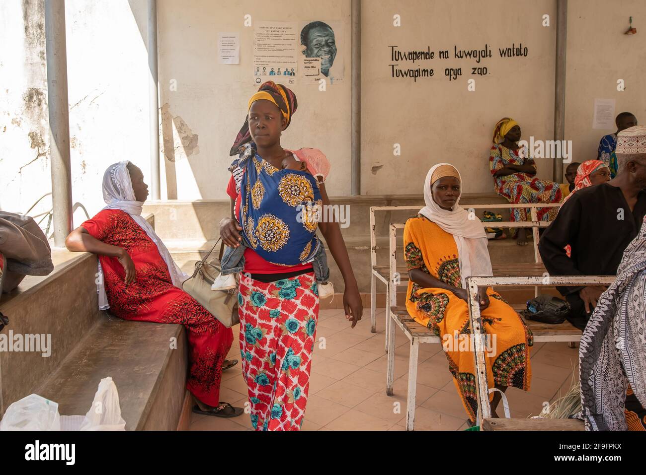 Dodoma, Tanzania. 10-10-2018. Young black muslim mother holding her baby on her arms is going to receive treatment by a doctor in a rural hospital in Stock Photo