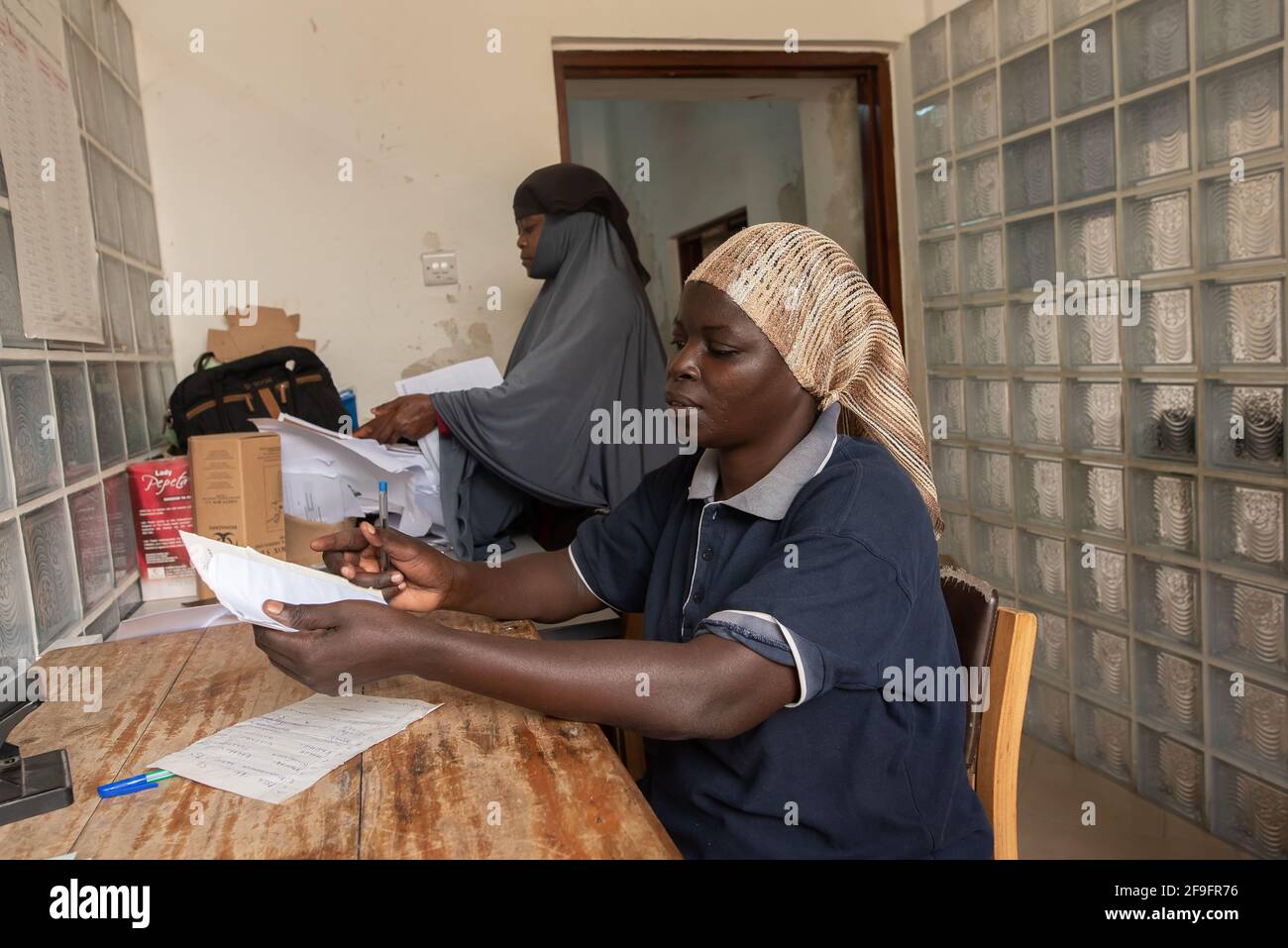 Dodoma, Tanzania. 10-10-2018. Two black muslim woman work at the hospital in charge of the administrative work responsible for the files of all the pa Stock Photo