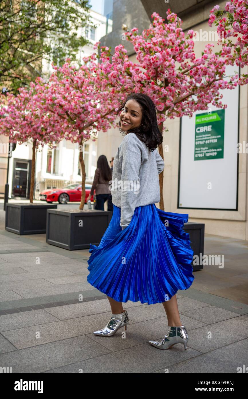 A model wearing a H&M grey jumper styled with a blue long Anthropologie  skirt and silver Bershka shoes seen during a street style photoshoot in  Bond Street, London. (Photo by Pietro Recchia /