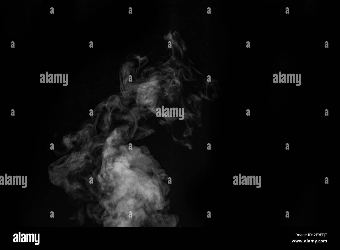 White vapor spray steam from air saturator. Smoke fragments on a black background. Abstract background, design element, for overlay on pictures Stock Photo