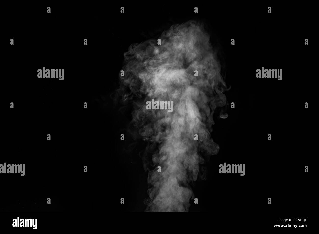 Figured smoke on a dark background. Abstract background, design element, for overlay on pictures. White smoke on black background. Stock Photo
