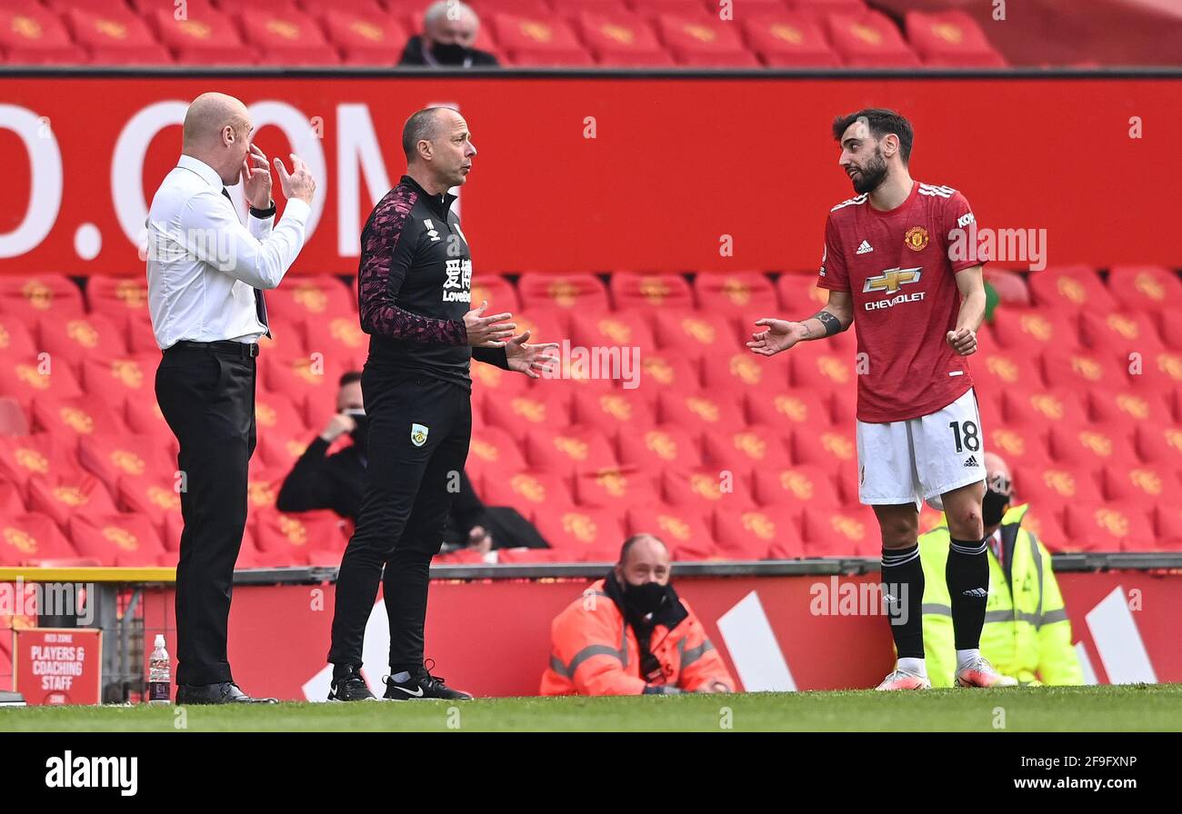 Manchester United's Bruno Fernandes exchanges words with Burnley manager Sean Dyche (left) and assistant Ian Woan during the Premier League match at Old Trafford, Manchester. Picture date: Sunday April 18, 2021. Stock Photo