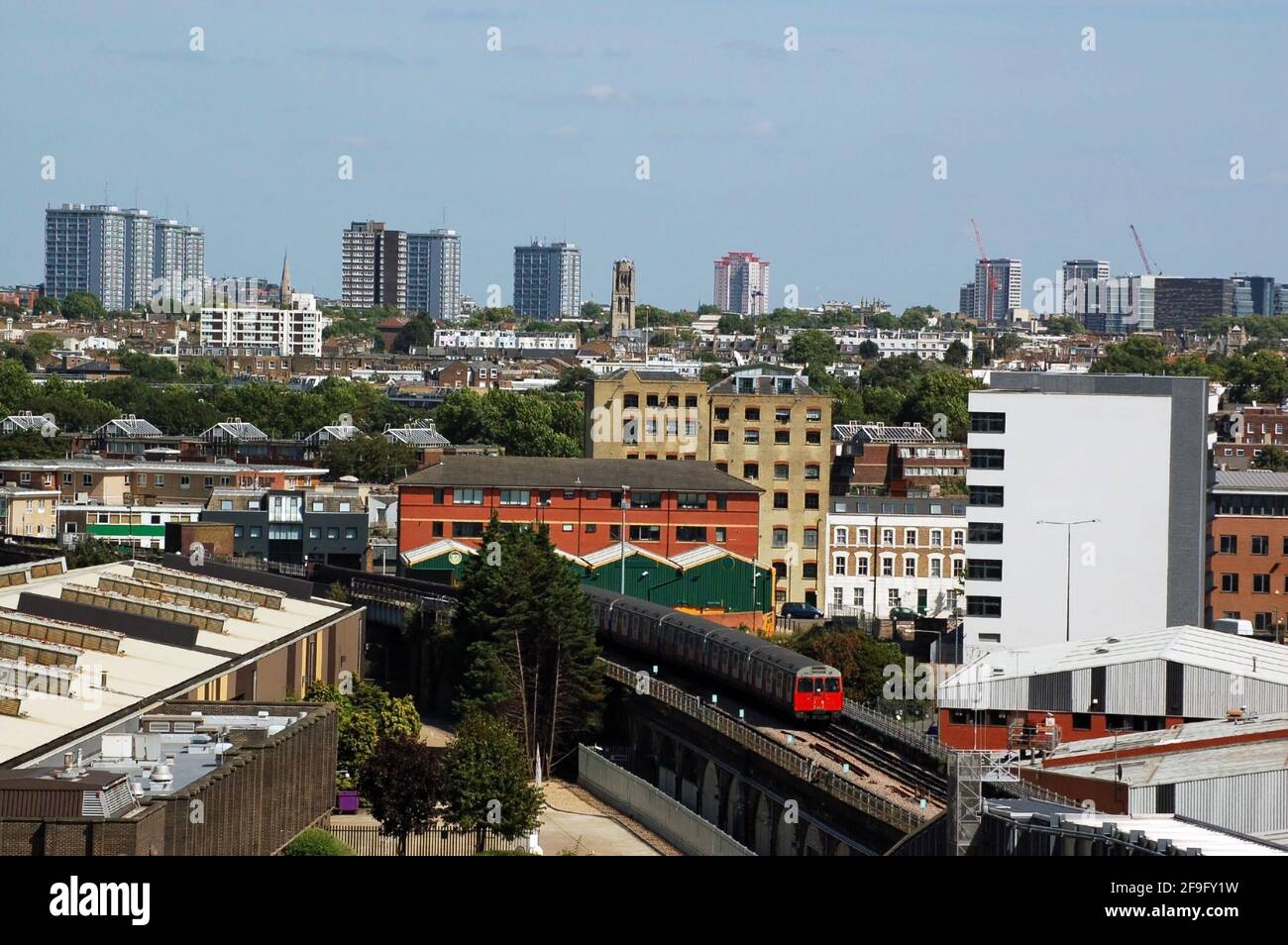 A view from Shepherd's Bush looking across Notting Hill and North Kensington towards the centre of London. A tube train on the Hammersmith and City un Stock Photo