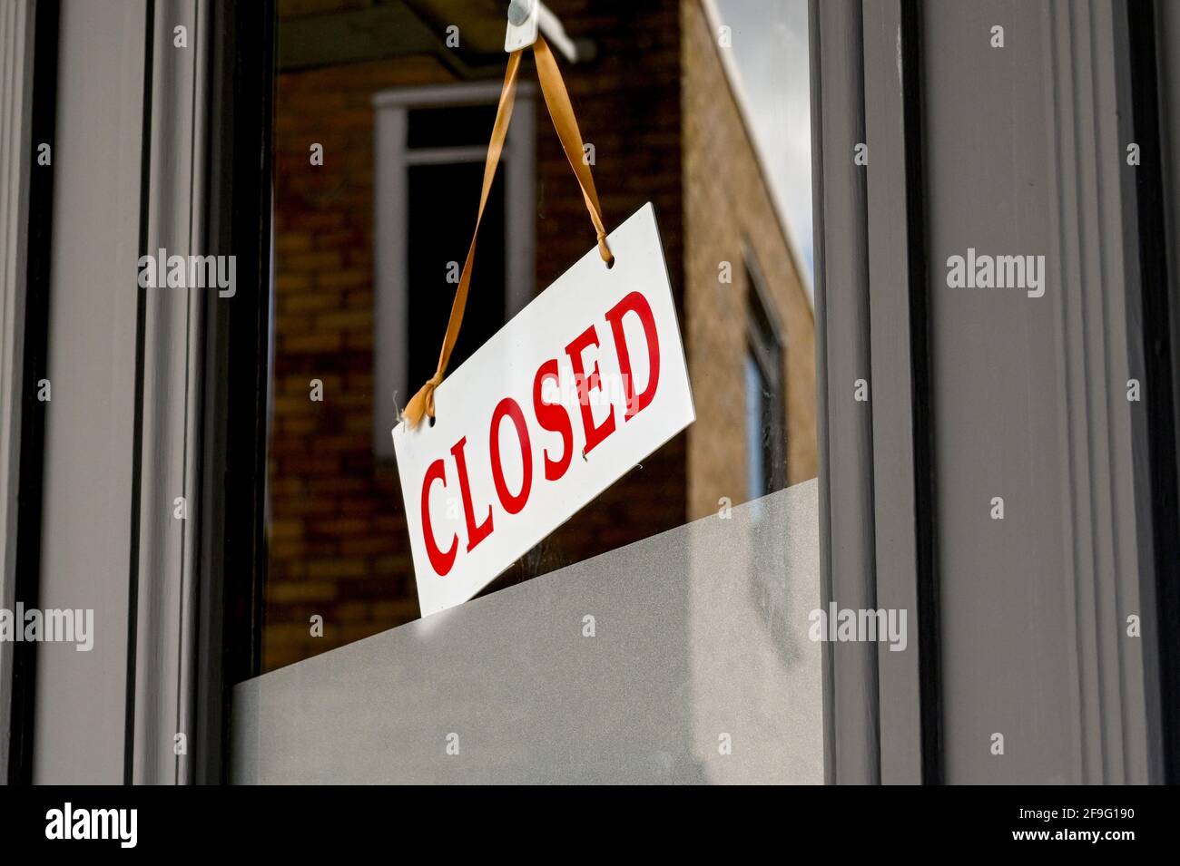 Closed sign in the window of a business which was forced to shut during