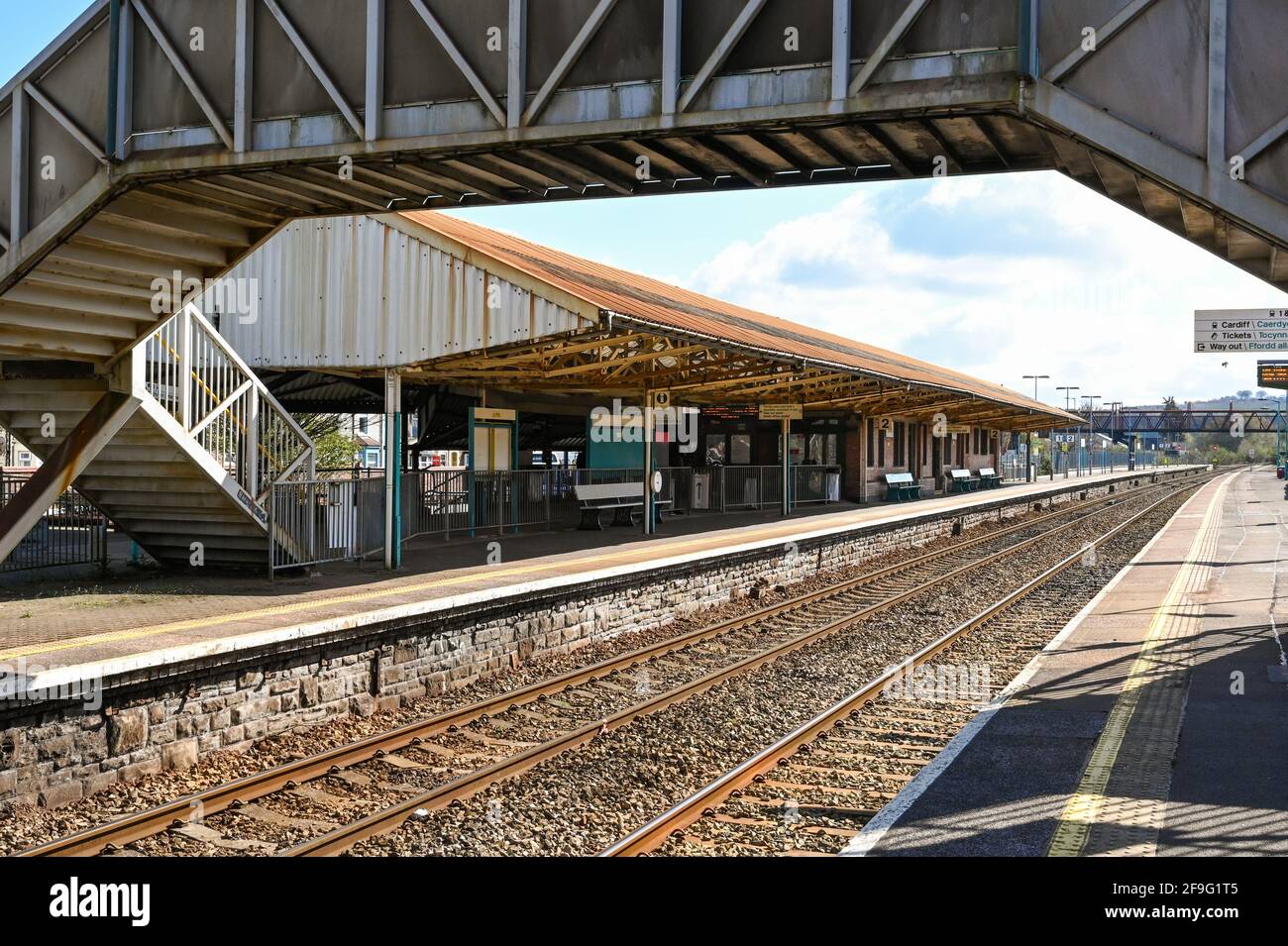 Caerphilly, Wales - April 2021: Platforms at Caerphilly railway station with footbridge framing the view. Stock Photo